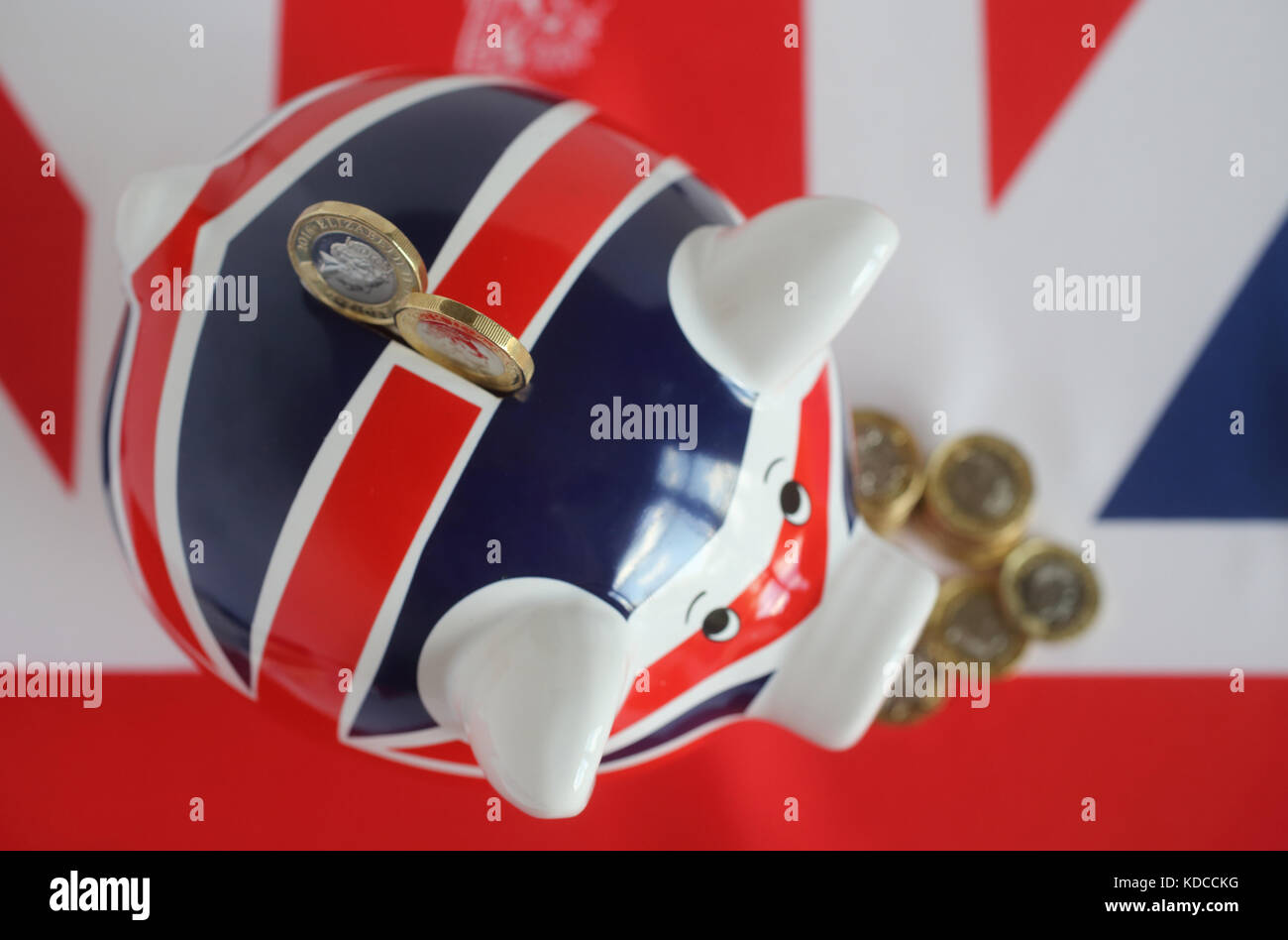 New British pound coins with a Union Jack piggy bank Stock Photo - Alamy