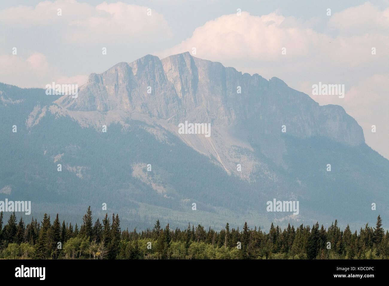 A mountain is visible in Kananaskis country through the haze of smoke from forest fires. Stock Photo