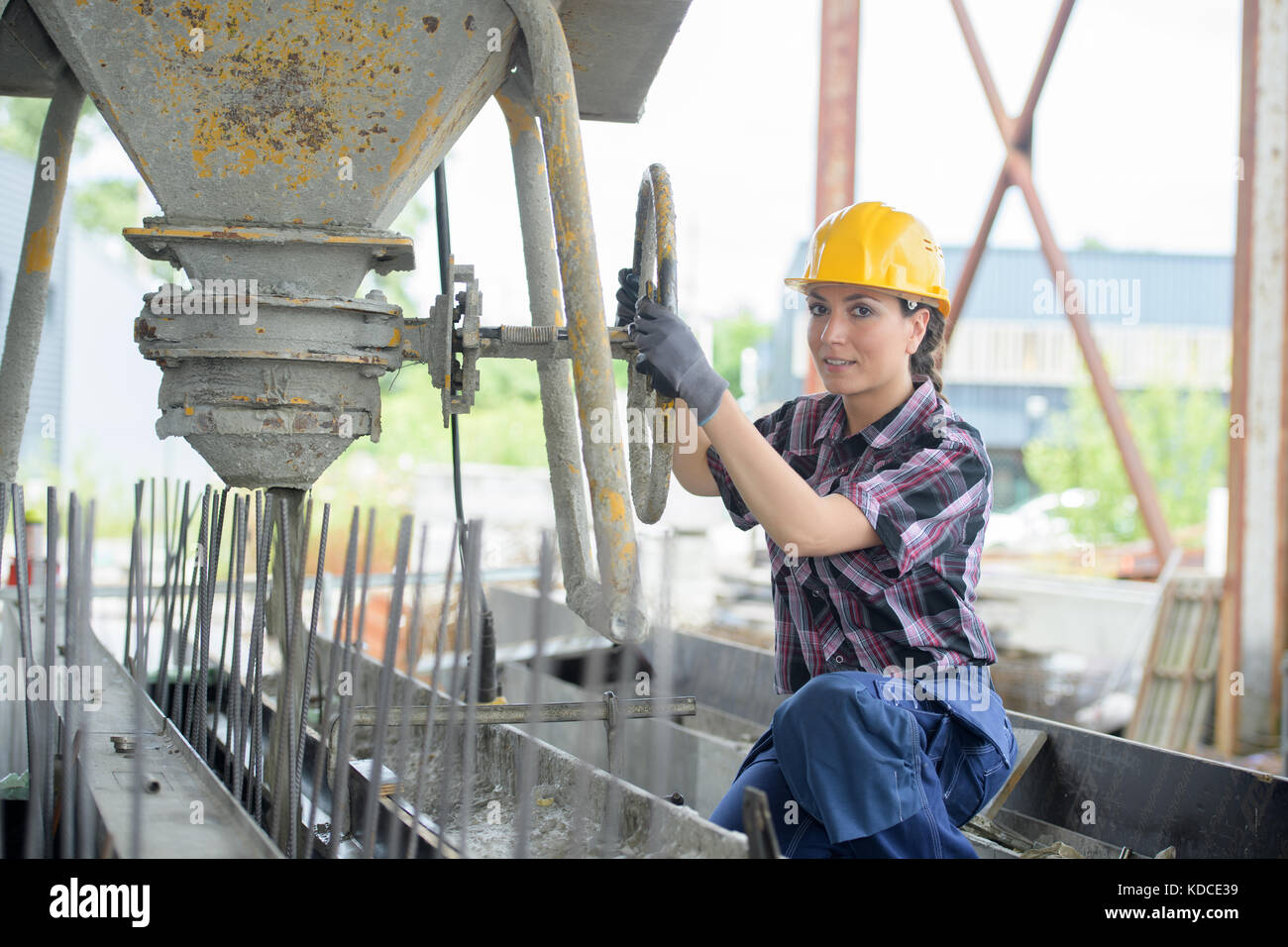 portrait of diligent positive female engineer rotating valve on tank Stock Photo