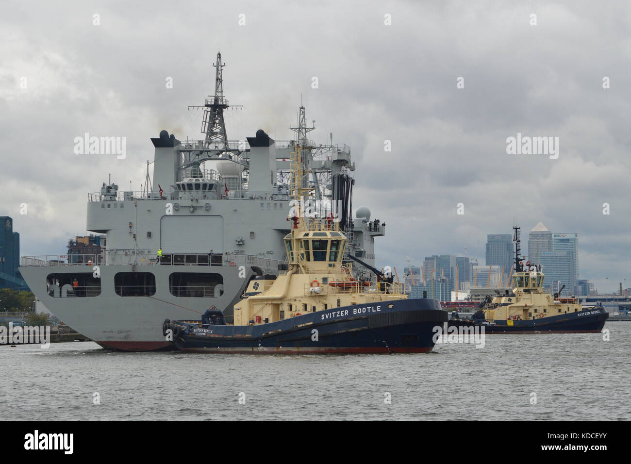 Svitzer Tug assist departure of Chinese Navy Replenishment Ship PLAN Gaoyouhu AOR 966 from the King George V Lock in London's Royal Docks Stock Photo