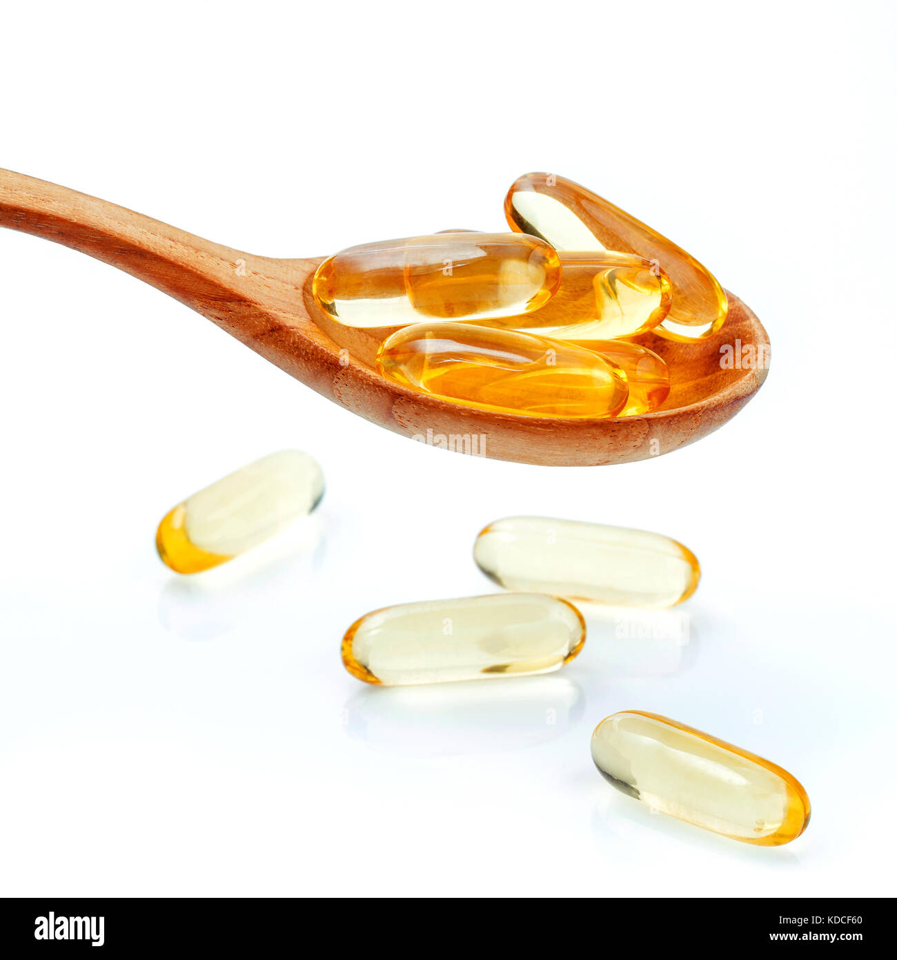 Spoonful of gel capsules of omega 3. Close up capsules fish oil in wooden spoon .The supplement high vitamin E, omega 3 and DHA . Capsules fish oil wi Stock Photo