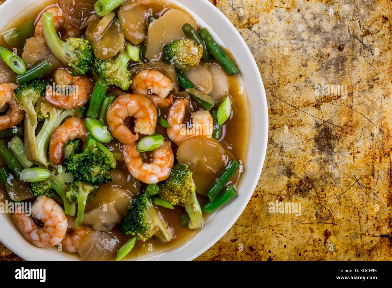 Chinese Style Stir Fried King Prawn With Ginger and Spring Onions On A Distressed Oven or Baking