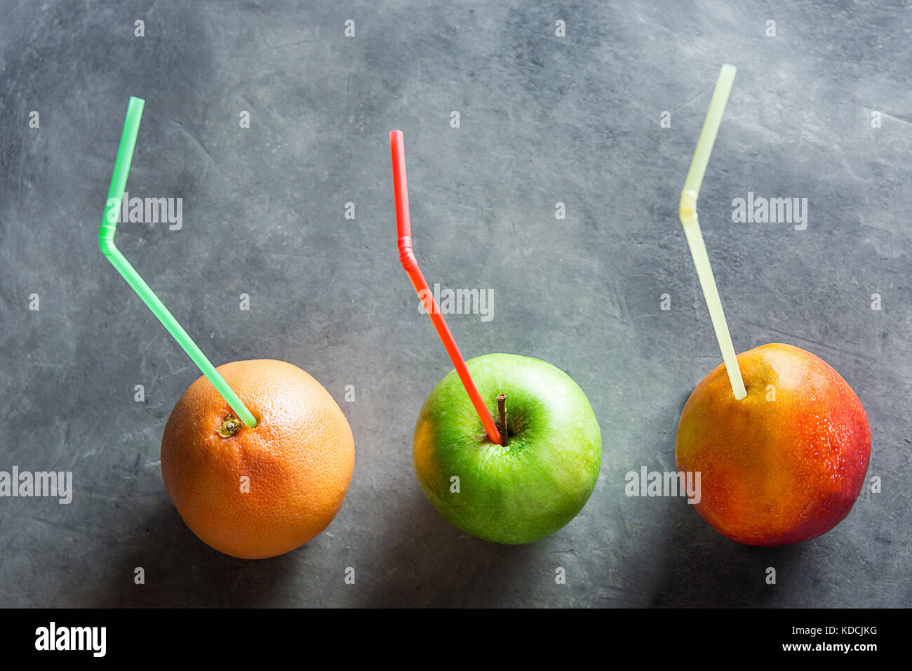 Colorful Ripe Organic Fruits Mango Grapefruit Apple with Straws Fresh Juices Health Detox Cleansing. Dark Background Menu Poster Template Copy Space.  Stock Photo