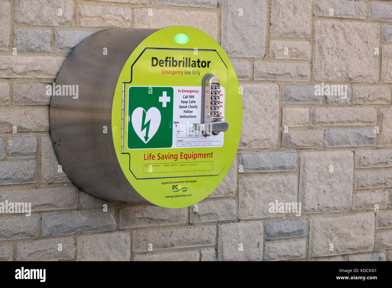 A life saving, cardiac defibrillator mounted to a wall in a public space for use by a member of the public in an emergency. Stock Photo