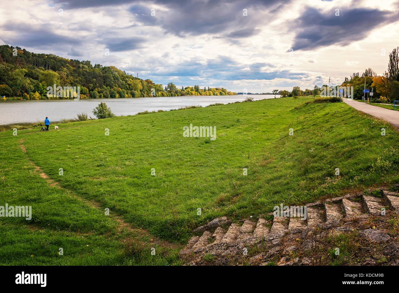 Riverbank of Vah river in Piestany (Slovakia) - woman with dogs Stock Photo