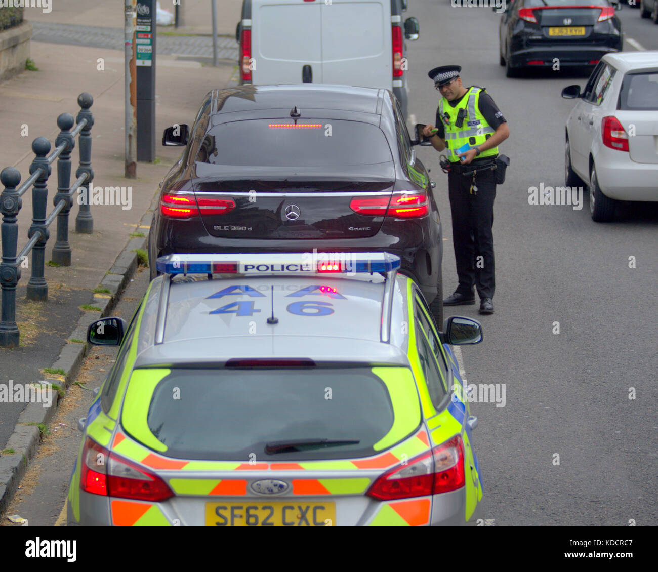 police officer pulls over motorist for questioning on busy road Stock Photo