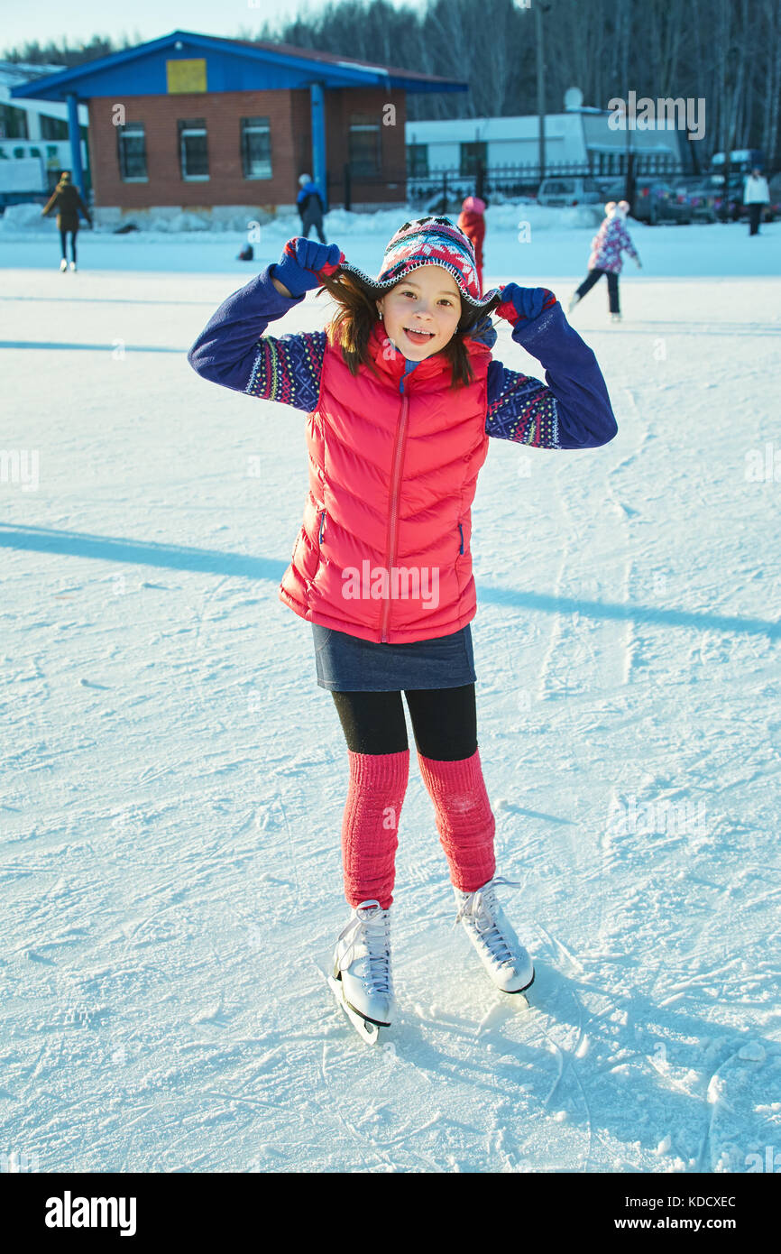cute little girl ice skating. child winter outdoors on ice rink Stock