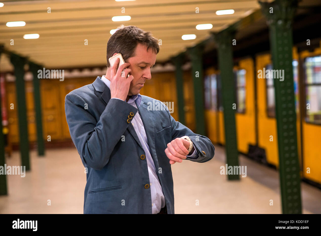 A middle age businessman standing and waiting in the subway while ...