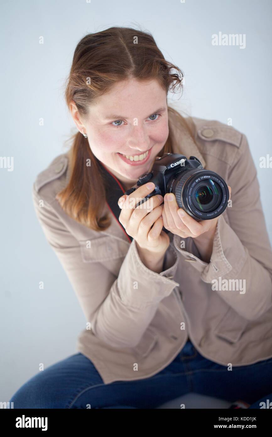 Woman sits DSLR camera Stock Photo