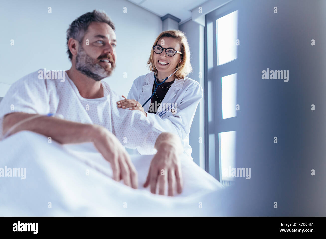 Female doctor checking male patient. Doctor visiting and talking with