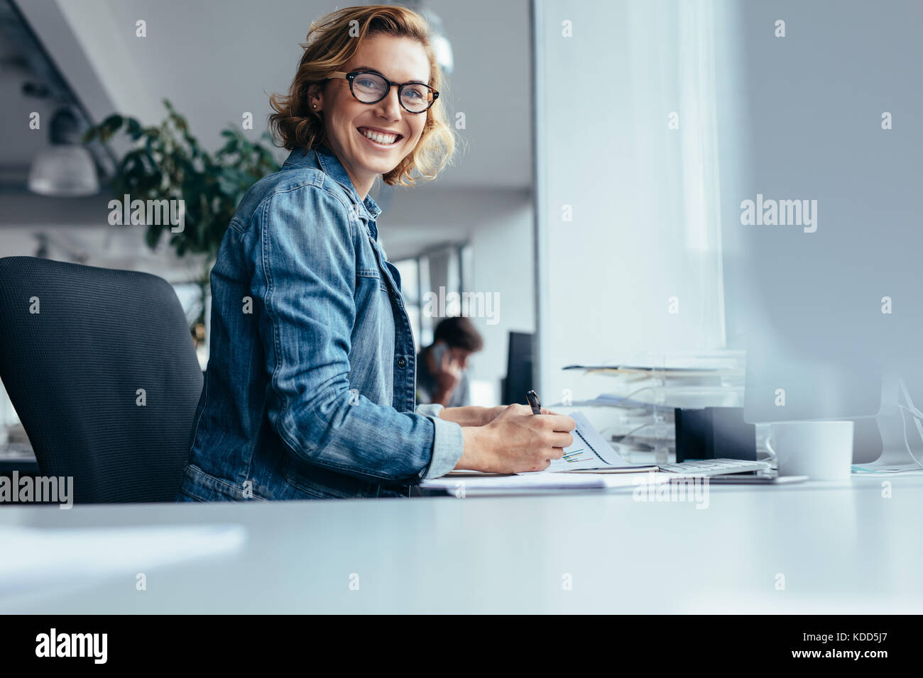 Female manager working at her desk. Smiling businesswoman sitting in ...