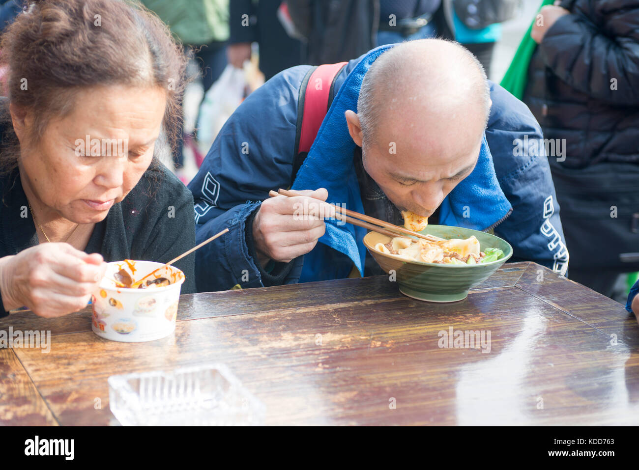 An elderly couple was having traditional Chinese noodles. Stock Photo