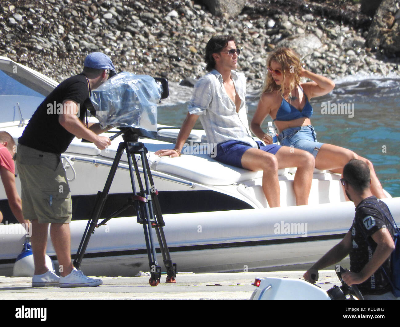 Jeremy Irvin and Lily James sit on the edge of a boat as they film