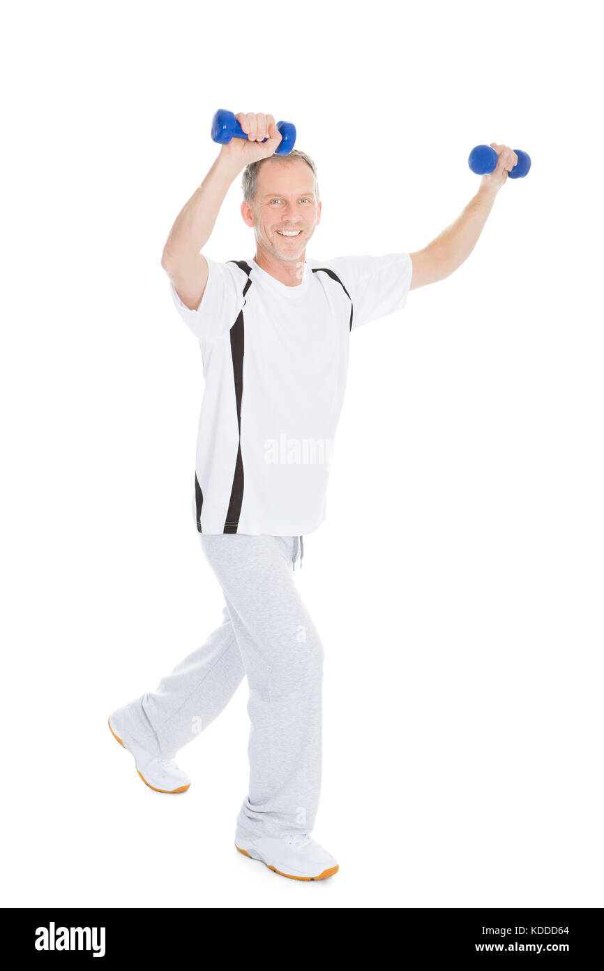 Mature Man Exercising With Dumbbells Over White Background Stock Photo
