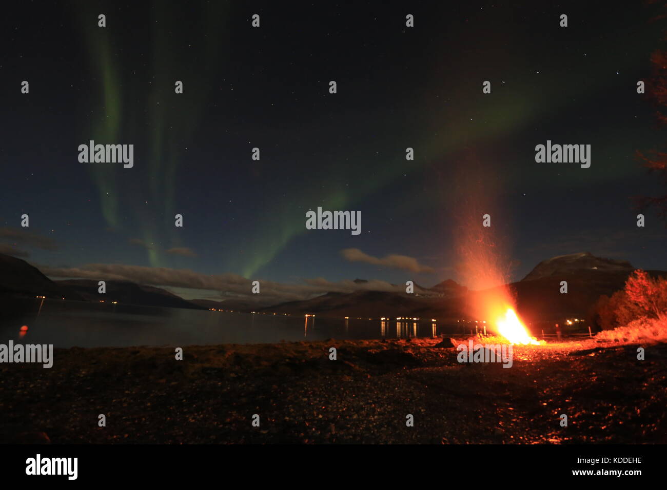 Northern LIghts Over The Sea And Bonfire Stock Photo