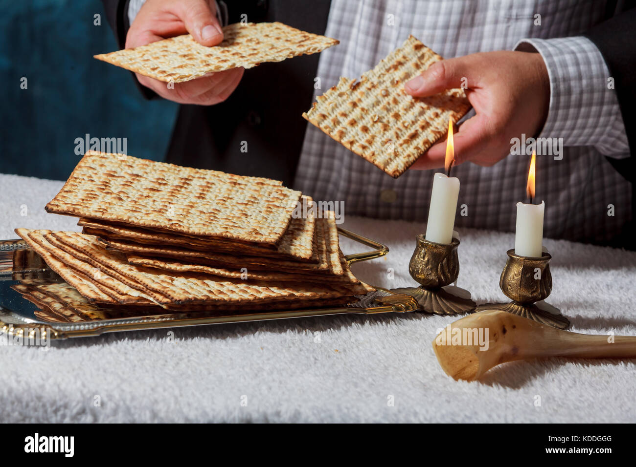 Jewish men is blessing on Matzah unleavened bread while another wearing