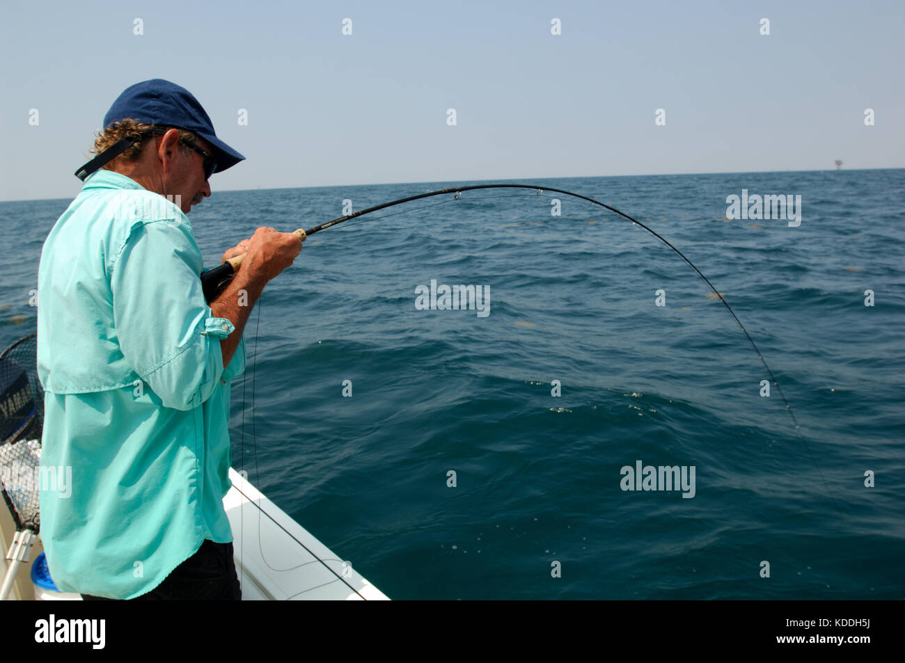 A fly fisherman fights a big fish while fishing offshore from Freeport, Texas Stock Photo
