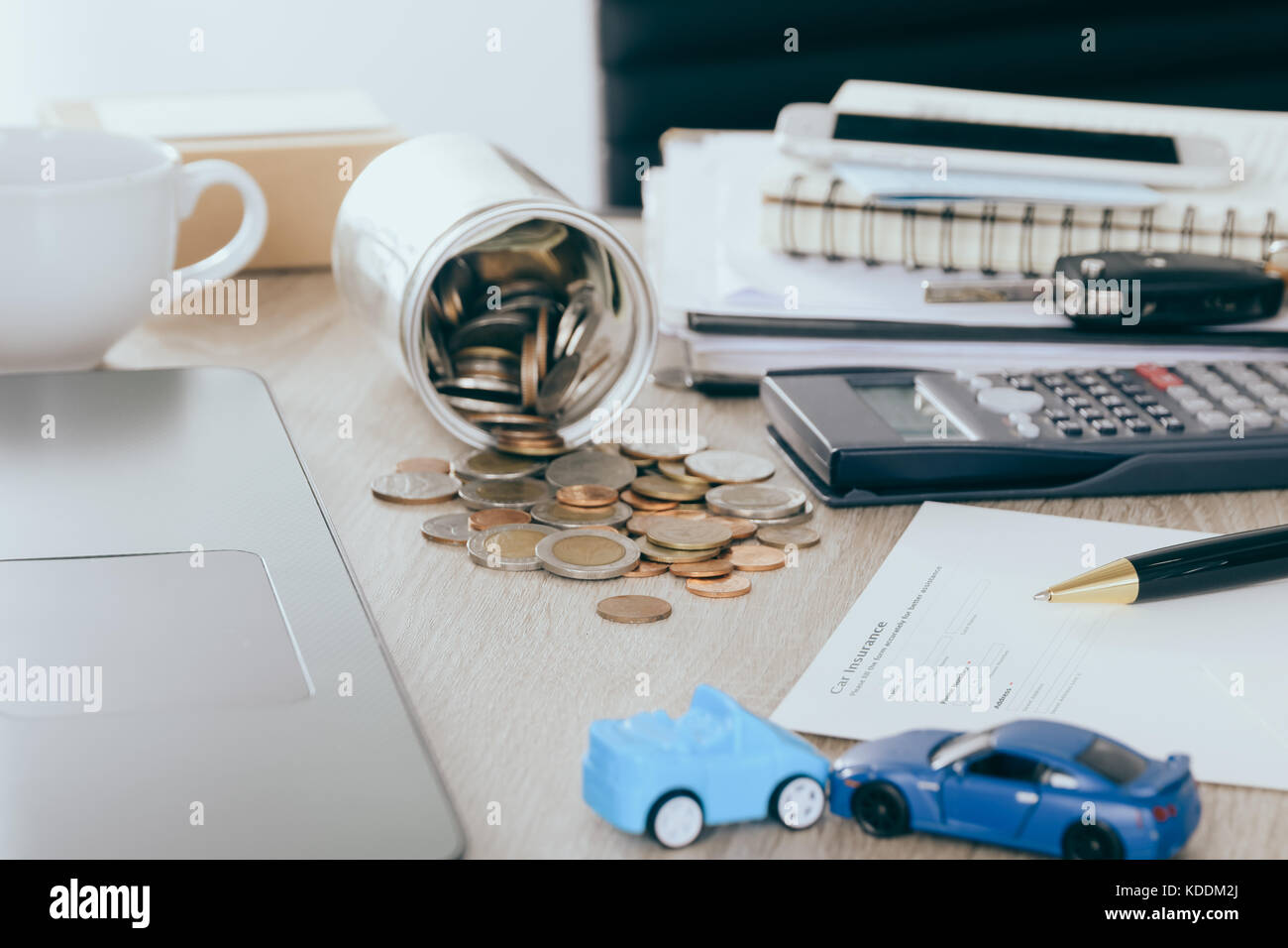Car insurance concept:Car claim form with car toy crash on desk with Money flow out of jar coin bank Stock Photo