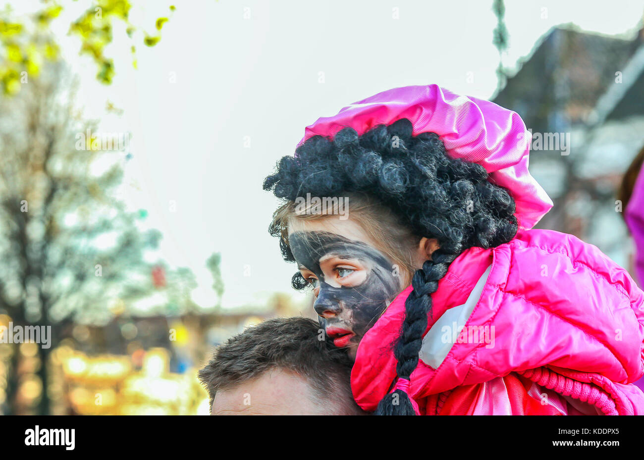 GRONINGEN, NETHERLANDS-NOV 19:Small Dutch girl with black paint on face symbolizes black Piet at Sinterklaas feast on Nov 19, 2012. The Dutch Sinterkl Stock Photo