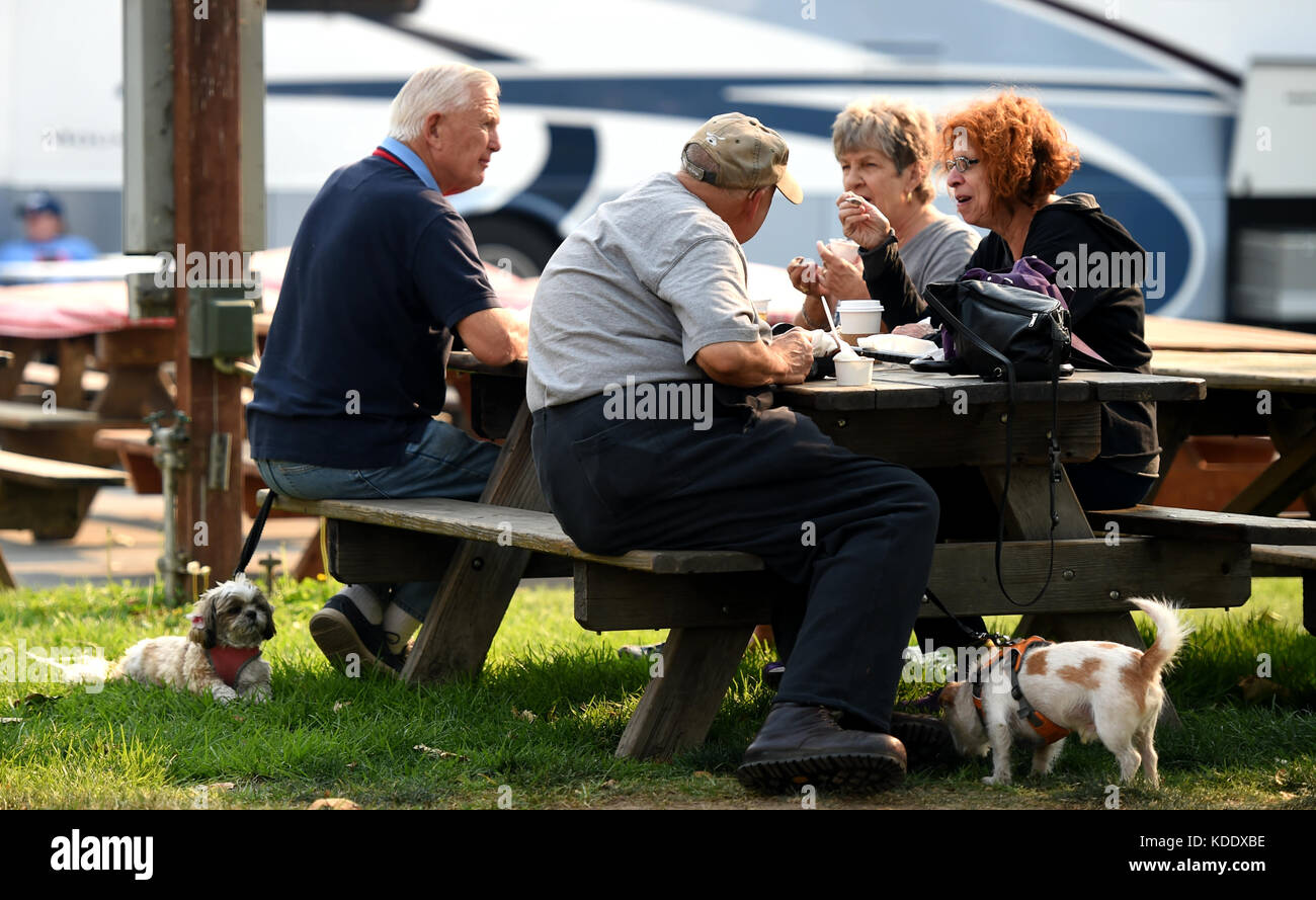 Santa Rosa, USA. 12th Oct, 2017. People with their dogs rest at a temporary settlement in Santa Rosa, California, the United States, on Oct. 11, 2017. California Governor Jerry Brown offered his sympathy Thursday to the victims of wildfires that are ravaging the state, and will visit the effected areas soon, as the death toll hit a new high of 29, local media reports said. Credit: Wu Xiaoling/Xinhua/Alamy Live News Stock Photo