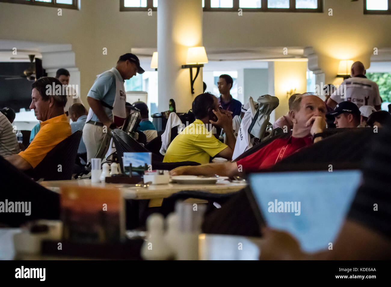 Kuala Lumpur, Malaysia. 13th October, 2017. PGA official suspend play as rain and thunder over shadow Round Two play at PGA CIMB Classic 2017 golf tournament in Kuala Lumpur, Malaysia. Players and caddies wait out the rain in the club cafe. © Danny Chan/Alamy Live News. Stock Photo