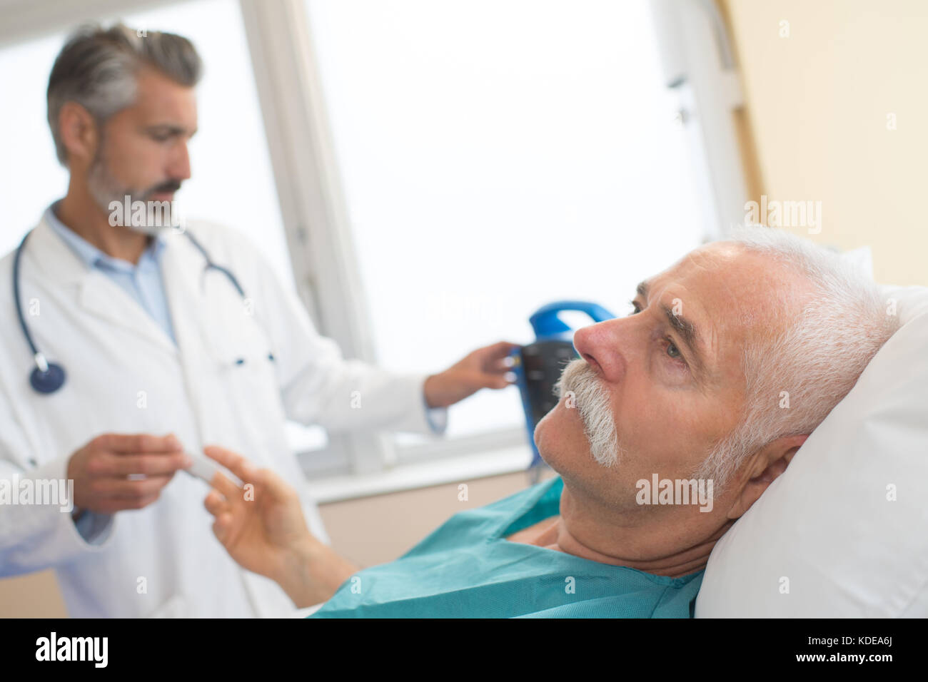 doctor with sick old man lying in hospital bed Stock Photo Alamy