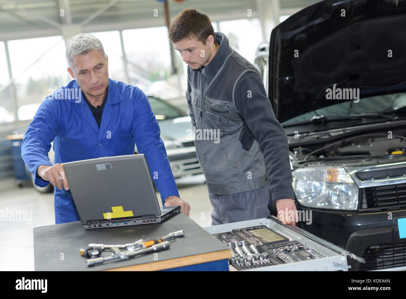 auto mechanic teacher and trainee performing tests at mechanic school