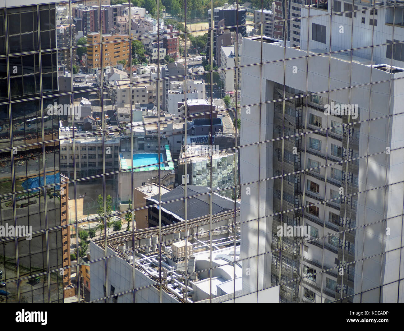 View of reflections in the glass windows of a tower of buildings in Osaka Japan Stock Photo