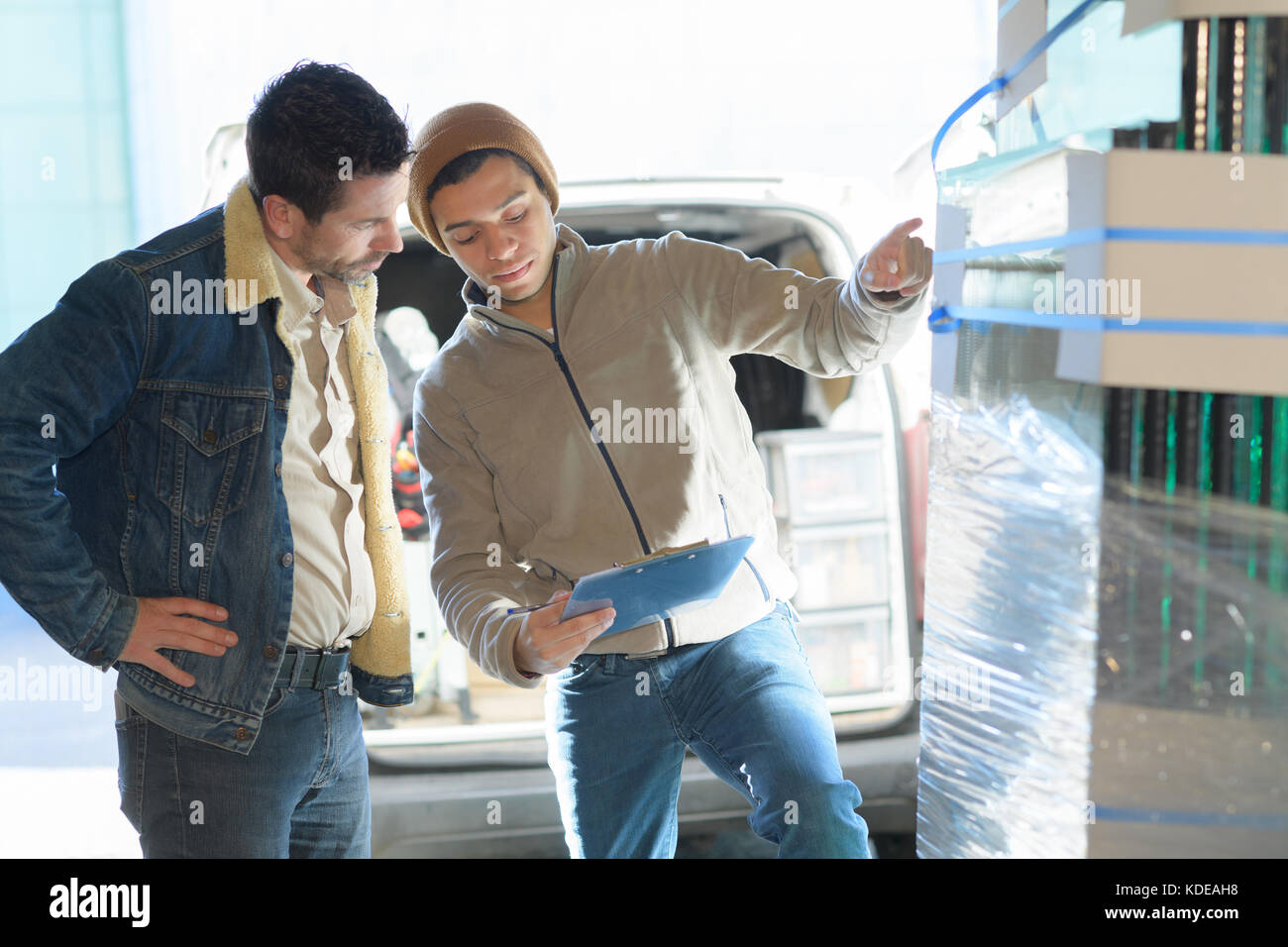 2 male workers checking stock in a warehouse Stock Photo - Alamy