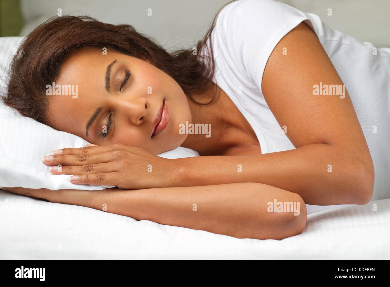 Young hispanic woman lying in a bed. Stock Photo