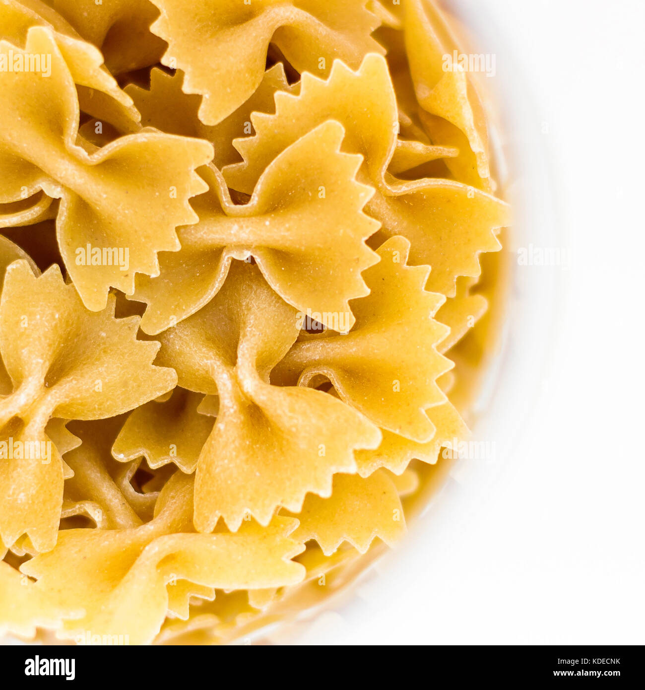 Bow tie pasta in bowl, isolated on white background, top view Stock
