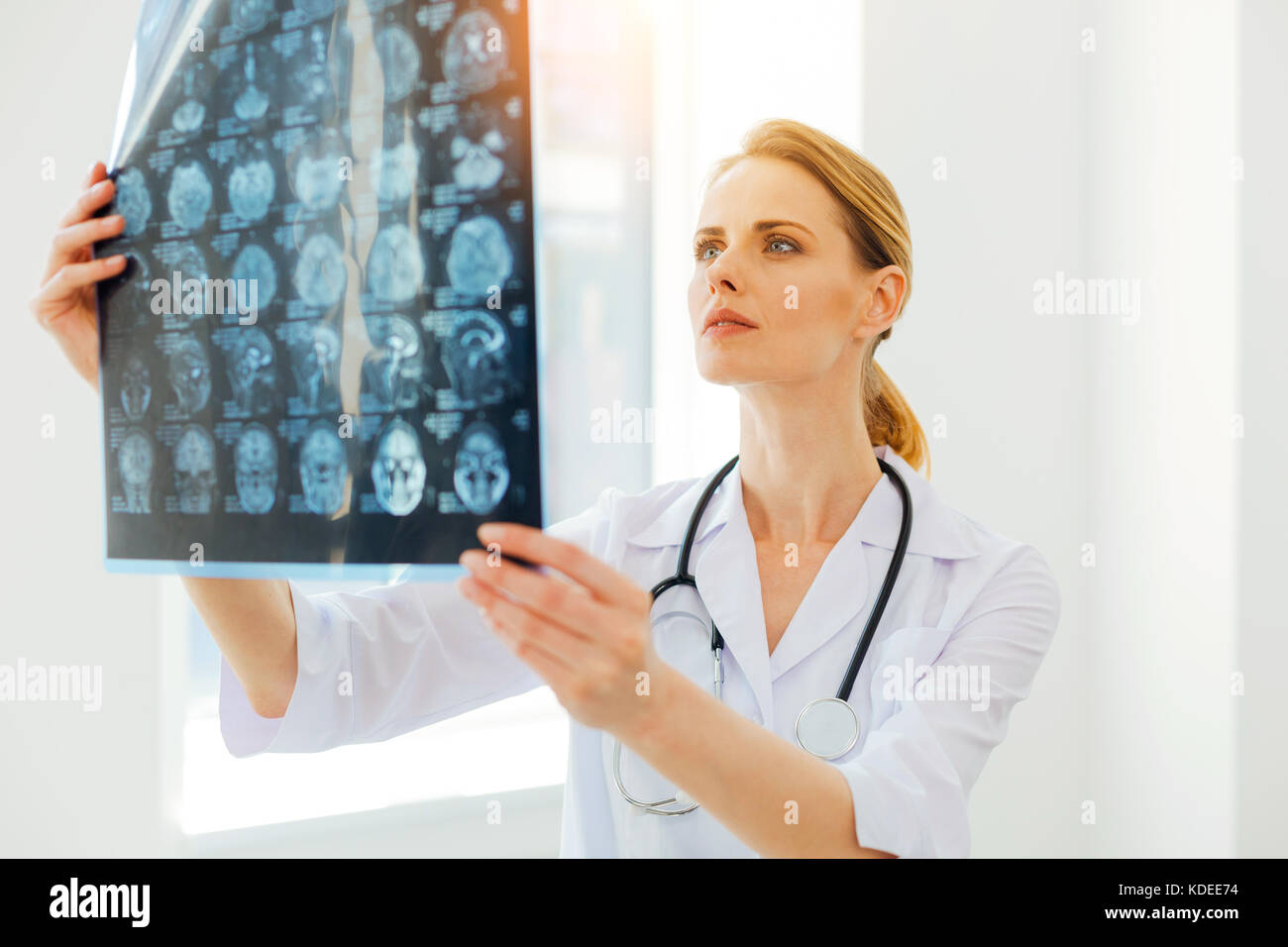 Serious female radiologist examining MRI scan image Stock Photo