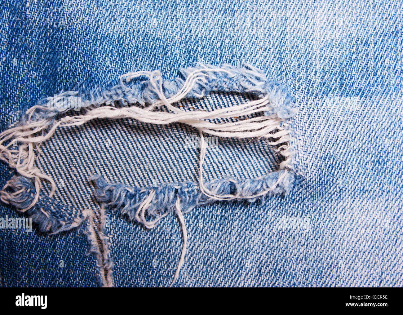 The hole on the blue jeans, denim texture Stock Photo - Alamy
