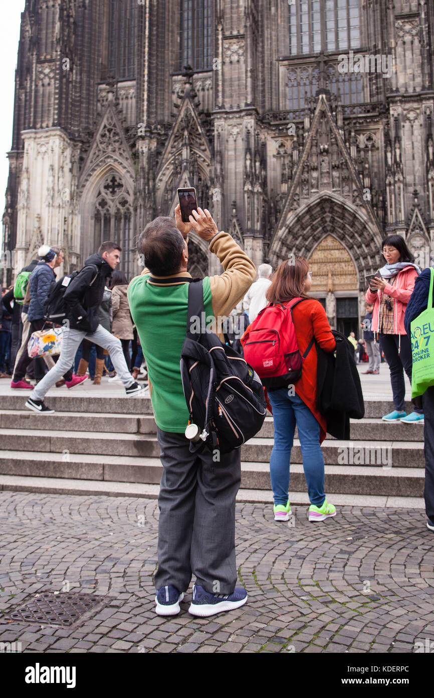 Europe, Germany, Cologne, tourist taking pictures of the cathedral with his smartphone.  Europa, Deutschland, Koeln, Tourist fotografiert den Koelner  Stock Photo