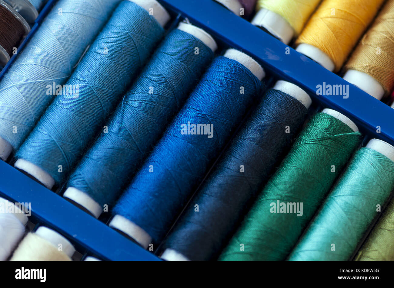 Close-up on colored sewing threads on spools Stock Photo - Alamy