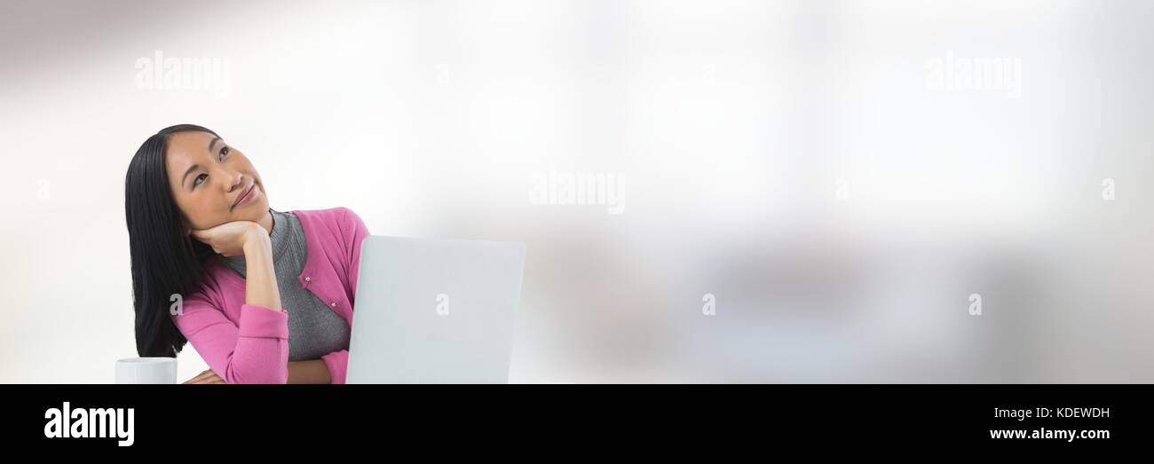 Digital composite of Businesswoman on laptop with bright background Stock Photo