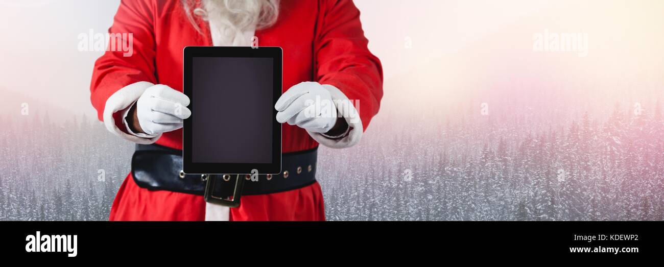 Digital composite of Santa with Winter landscape and tablet Stock Photo ...