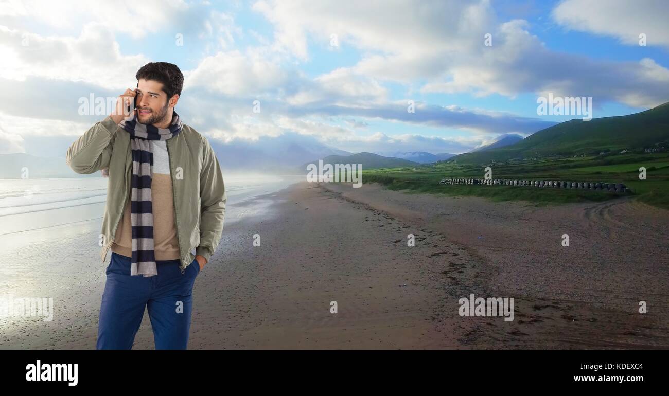 Digital composite of Businessman on phone on beach Stock Photo