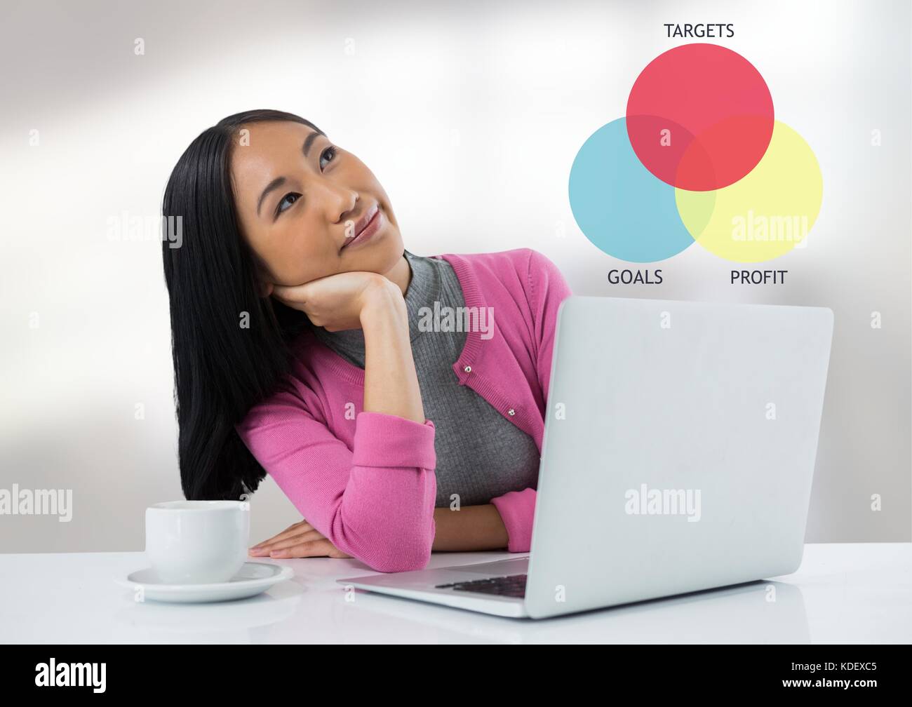 Digital composite of Businesswoman at desk with laptop and target and goals chart Stock Photo