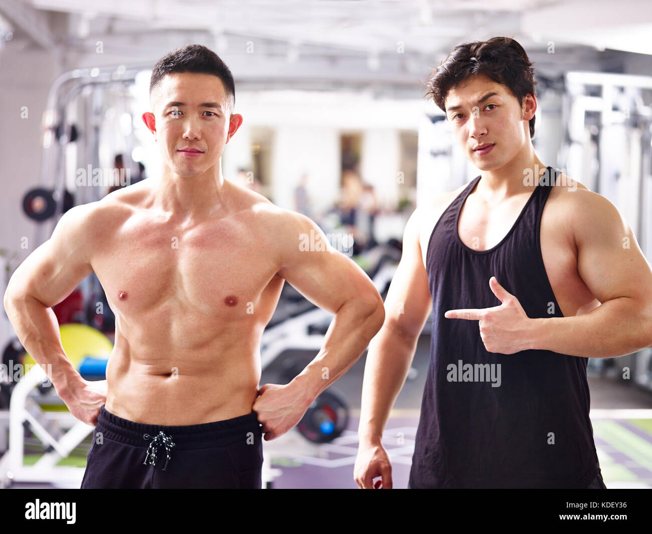 portrait of two young asian bodybuilders posing in gym. Stock Photo