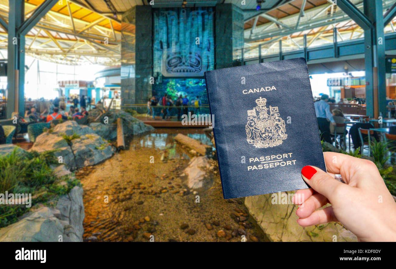 Vancouver International Airport - 11 April, 2017: Hand holding a Canadian passport at Vancouver International Airport lounge Stock Photo