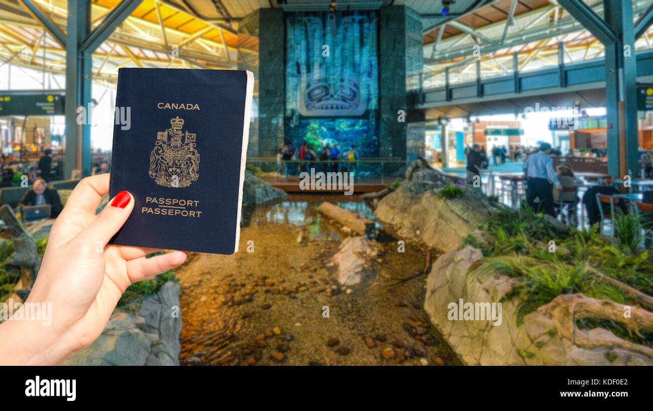 Vancouver International Airport - 11 April, 2017: Hand holding a Canadian passport at Vancouver International Airport lounge Stock Photo