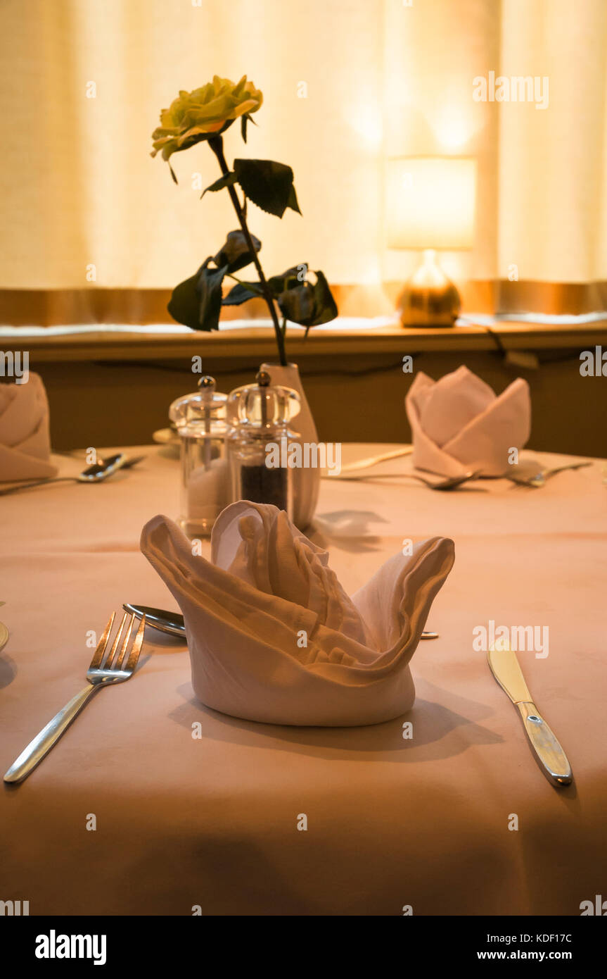 Flowers and place settings in an eating establishment, Lancashire,England Stock Photo