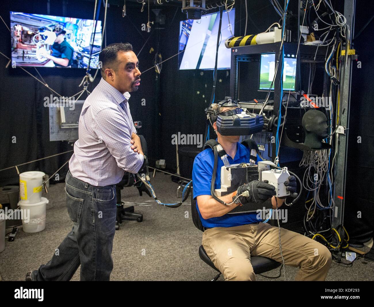 NASA Extravehicular Activity Trainer Steve Vilano coaches NASA astronaut Nick Hague as he uses a