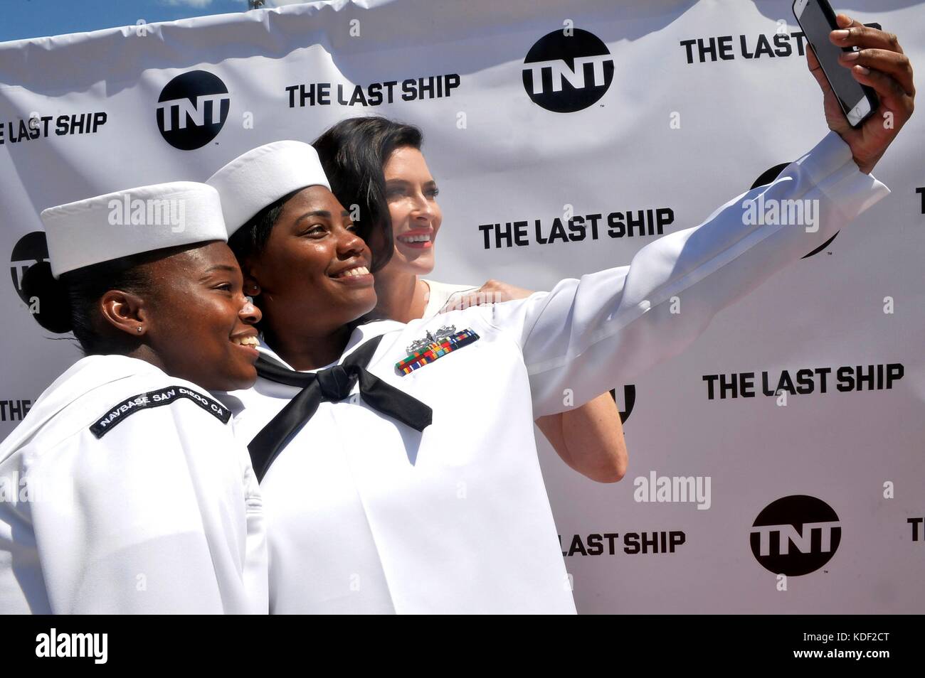 U.S. sailors take a selfie photo with actress Bridget Regan on the red carpet during the Season 4 premiere of the TNT TV show The Last Ship at the Naval Base San Diego Theater July 23, 2017 in San Diego, California.   (photo by Indra Bosko  via Planetpix) Stock Photo