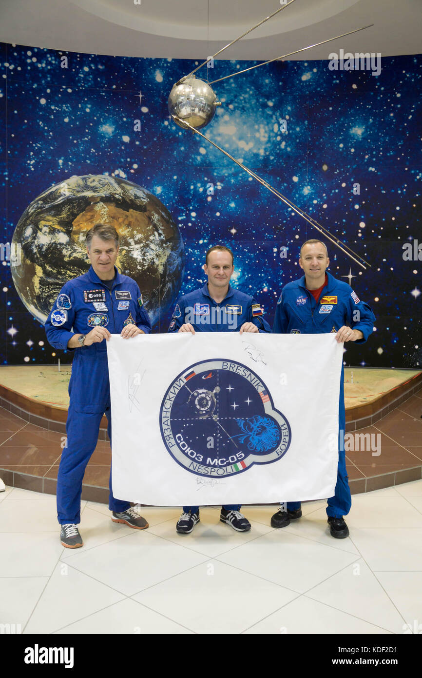 NASA International Space Station Expedition 52 prime crew members (L-R) Italian astronaut Paolo Nespoli of the European Space Agency, Russian cosmonaut Sergey Ryazanskiy of Roscosmos and American astronaut Randy Bresnik hold up a flag with their Soyuz MS-05 spacecraft insignia at the Baikonur Cosmodrome Korolev Museum during traditional pre-launch activities July 24, 2017 in Baikonur, Kazakhstan.    (photo by Victor Zelentsov  via Planetpix) Stock Photo