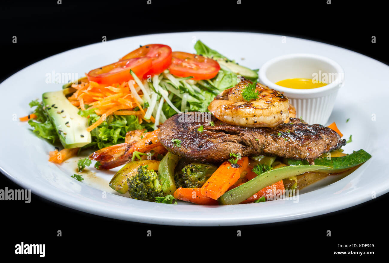 grilled flank steak and jumbo shrimp served with a side salad Stock