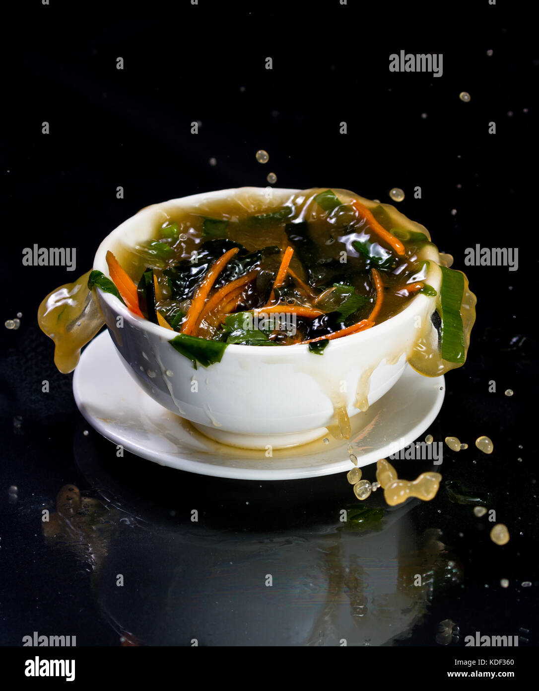 splashing cup of miso soup with liquid and vegetables flying everywhere Stock Photo Alamy