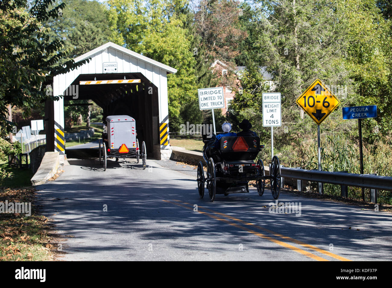 Lancaster County PA Amish buggies at covered bridge. Stock Photo