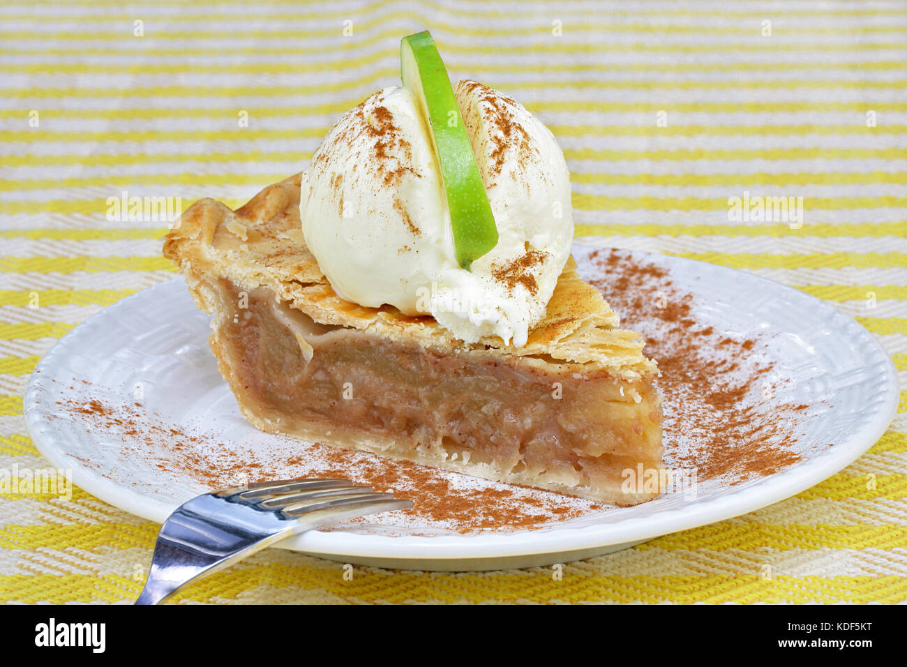 One slice of apple pie with vanilla ice cream on top and a ...